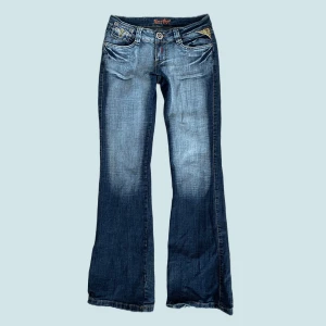 Miss Vivi Low Waist Jeans - Jättesnygga lågmidjade bootcutjeans från Miss Vivi. Använda ett fåtal gånger men har några revor längst ner (se bild 2). Midjemått - ca 34cm över och 68cm runt. Passar på mig som bär storlek 36. Innerbenslängd - ca 81,5cm Kontakta mig för fler bilder 🦋
