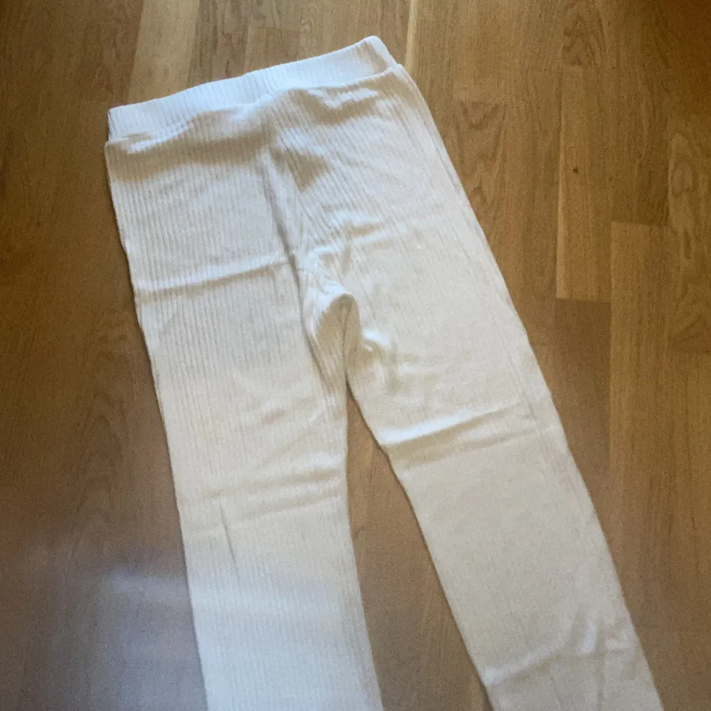 Ett par vita ribbstickade byxor med lite  bootcut från ginatricot i st M. Dom är i bra skick och använda få gånger. Nypris 250kr. Jeans & Byxor.