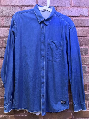 Jeans skjorta  - jeans skjorta från jack and jones en knapp är sönder men det sitter en extra knapp på lappen längst ner på skjortan