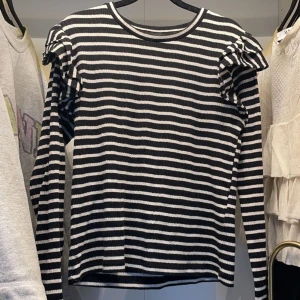 Randig tröja med volang på axlarna - Säljer denna svart vit randiga tröjan med volanger från zara! Köptes i början av dec 2021 och har inte kommit till användning sen dess. Kan tänka mig och sälja för 100kr 💓 inga defekter! 