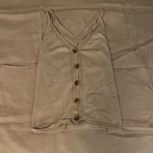 NA-KD linne/tröja - En fin och beige tröja/linne, som har 5 bruna knappar på framsidan, storlek XS