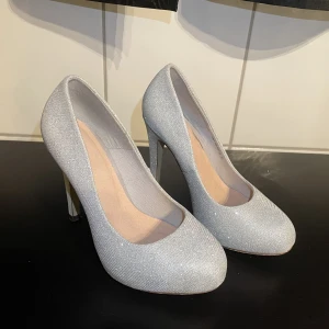 Klackskor - Silver glittriga klackar i storlek 35. Använda fåtal gånger  Bra skick