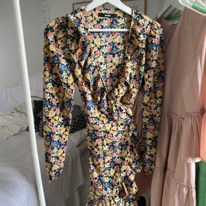 Sommarklänning från BikBok - Jättefin klänning i snyggt blommönster från bikbok. Storlek S men passar nog både mindre och större eftersom de är en omlottmodell. Använd två gånger, väldigt fint skick