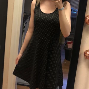 Prickig klänning  - En prickig klänning som är väldigt mörk blå nästan svart i storlek s