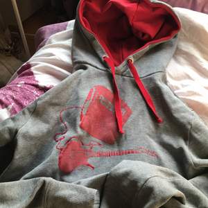 En grå och röd hoodie som inte läbgre används köpt på secondhand!:)