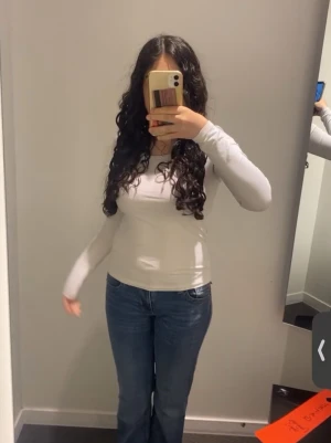 Vit långärmad basic topp - En enkel och stilren vit långärmad topp med rund hals. Modellen är figurnära och passar perfekt till både jeans och kjol. 