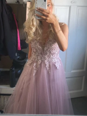 Balklänning - Jättefin ljusrosa prinsess balklänning med två lager kjol så du håller dig varm om det är kyligt, det yttersta lagret är lite glittrigt vilket är såå fint i solljuset💕Det är jättefina detaljer högst upp på klänningen vid brösten, blommor och lite pärlor, den är också v-ringad och en dragkedja där bak som går ner långt så det är lätt att komma i klänningen, den är i storlek 36 men jag är en XS-S och 36 passade mig jättebra, så klänningen passar XS-36! Nyskick , använd en gång🤗Nypris 5200