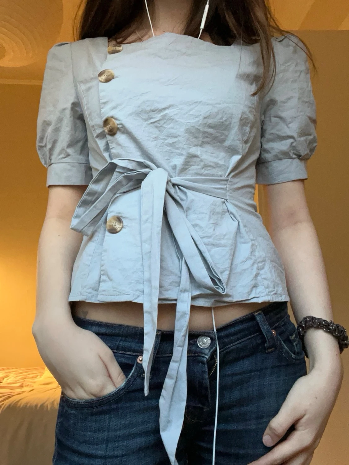 Ljusblå blus med knappar och knytband