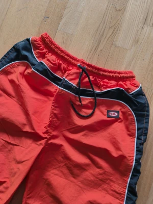 Orange svarta och vita shorts från Diesel  - Säljer ett par snygga shorts från Dieseli orange med svarta och vita detaljer. De har elastisk midja med dragsko och är tillverkade i ett snabbtorkande material. Perfekta för stranden eller poolen!