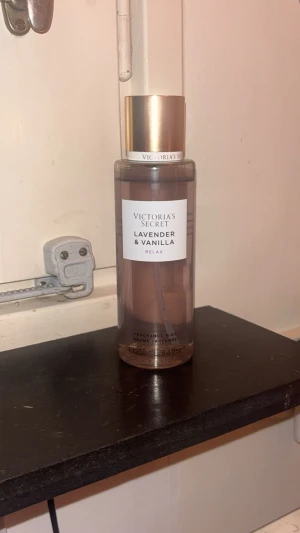 Victoria's Secret Lavender & Vanilla - Fräsch doftmist från Victoria's Secret i doften Lavender & Vanilla. Flaskan är genomskinlig med lila toner och har ett elegant guldlock. Perfekt för dig som gillar blommiga och söta dofter. Innehåller 250ml. Använd, Ungefär 85% kvar