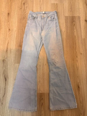 Ljusblåa utsvängda jeans - Säljer ett par ljusblåa jeans med riktigt breda utsvängda ben och klassisk femficksdesign. Jeansen har hög midja och är gjorda i denim. Perfekta för dig som gillar retrostil och vill sticka ut. Jeansen är från Bershka i storlek 38, passar även långa tjejer.