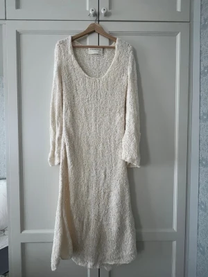 Vit stickad långklänning By Malene Birger - Lång, vit stickad klänning från By Malene Birger med rund halsringning och lång ärm. Hittar ingen storlek på klänningen men passar bra på mig som är strl S, men tror även den skulle passa för någon i strl M. Har endast använt fåtal gånger🤗