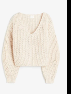 Beige stickad tröja från H&M - Mysig beige stickad tröja med djup v-ringning och breda ribbstickade muddar. Tröjan har en avslappnad passform och är tillverkad i ett tjockare garn som ger en chunky känsla. Perfekt för lager på lager och enkel att styla.