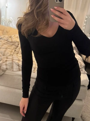 Svart långärmad v-ringad topp - En stilren svart långärmad topp med v-ringning. Sitter tight och har en enkel, klassisk design som passar till det mesta. Perfekt basplagg för garderoben.💓💓😙😙