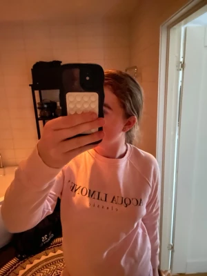 Ljusrosa sweatshirt från Acqua Limone - Säljer en ljusrosa sweatshirt från Acqua Limone med klassisk citronskiva i gult på ryggen och tryckt logga framtill. Tröjan har rund hals, långa ärmar och är gjord i mjuk bomull. Perfekt för chill dagar eller när du vill ha en färgklick i garderoben.
