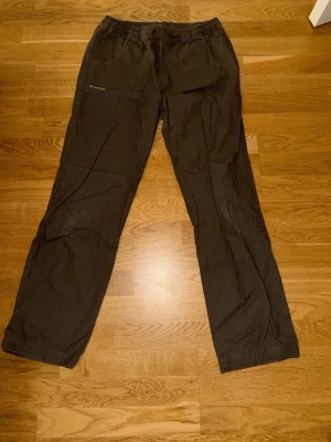 Svarta cargobyxor från Crossroads - Säljer ett par svarta cargobyxor från Crossroads med avslappnad passform, resår och dragsko i midjan. Byxorna har flera fickor både fram och bak, samt klassiska cargofickor på sidorna. Perfekta för en chill och streetinspirerad stil.