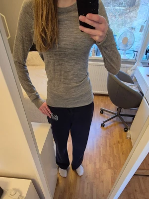 Grå tunnstickad tröja Selected Femme - Säljer en ljusgrå tunnstickad tröja från Selected Femme. Tröjan har rund halsringning, långa ärmar och en smal, figurnära passform. Materialet är mjukt och stretchigt, perfekt för lager på lager eller mysiga sommar kvällar. Diskreta slitsar i sidorna ger en snygg detalj.