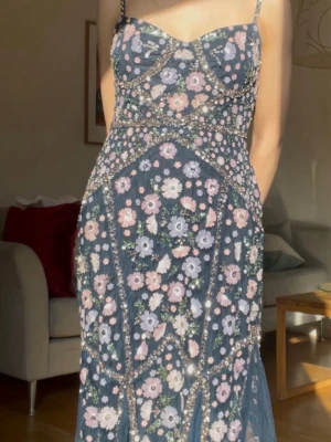 Bal klänning - Jättefin balklänning från märket Maya Deluxe som jag hade på min bal i 9an! Den har supermycket paljetter och fina detaljer med blommor som gör att den verkligen sticker ut💓Tyvärr finns ingen storlek i klänningen men den passar mig som brukar ha xs/32 i kläder perfekt men är något lång (är 160 ungefär), dock passar det bra med klackar ☺️ Banden går att båda förkorta och förlänga om man vill att klänningen ska bli längre /kortare. Några mindre revor som inte alls syns nere bak på klänningen.