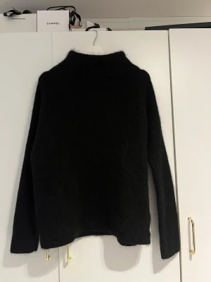 Svart stickad tröja H&M - Mysig svart stickad tröja från H&M i storlek 34 med hög hals och lång ärm. 