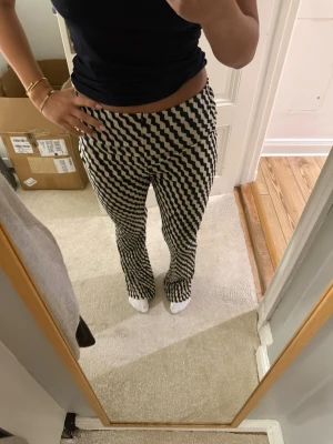 Mönstrade leggings i svart och vit - Säljer ett par snygga leggings med vågigt svart och vitt mönster. De har en tight passform och är stretchiga, perfekta för dig som vill sticka ut lite extra. Supersköna och trendiga, passar till både sneakers och boots. De är aldrig använda och har fortfarande lapp på.