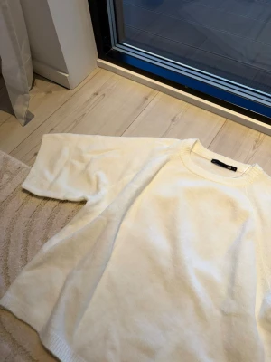 Vit stickad tröja från 157 - Säljer en vit stickad tröja från 157 med rund halsringning och korta, vida ärmar. Perfekt nu till våren då det börjar bli lite varmare. 
