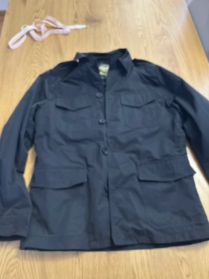 Svart fieldjacka  - Svart fieldjacka från Next i nyskick, perfekt till våren. Skönt material å bra kvalité. Säljes pga att den inte passade mig