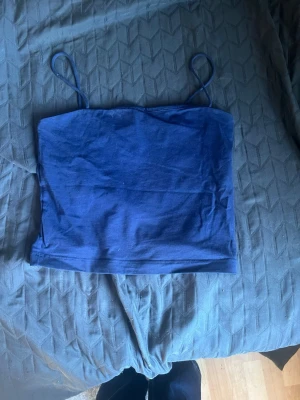 Mörkblå croppad linnetopp från Gina  - Snygg mörkblå croppad linnetopp med tunna axelband från Gina i storlek M. Enkel och stilren design som passar perfekt till jeans eller kjol. Tillverkad i mjuk bomull för en bekväm känsla. Perfekt för varma dagar eller lager på lager. Använda en gång💓