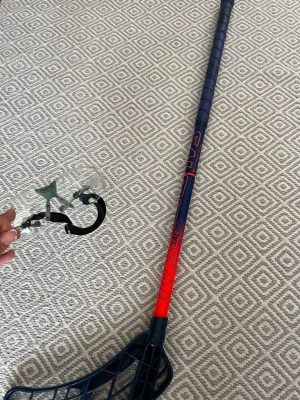 Innebandyklubba blå/röd - Säljer en blå och röd innebandyklubba med plastblad och greppvänligt skaft. Perfekt för innebandyträning eller match. Medföljer även ett par genomskinliga skyddsglasögon med svart och grått band. I nyskick