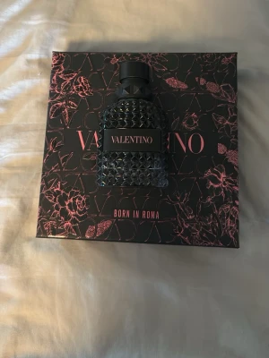 Valentino Born In Roma parfym - Säljer en Valentino Born In Roma parfym med en snygg svart flaska dekorerad med nitar och matchande svart lock. Kommer i en elegant svart kartong med rosa detaljer och blommönster. Perfekt för dig som gillar exklusiva och trendiga dofter. Runt 40 av 50 ml kvar.
