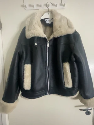 Svart teddyfodrad jacka från NA-KD - Säljer en snygg varm svart jacka från NA-KD 🖤  Jackan har krage, muddar och fickor i beige teddyfoder. Den har dragkedja framtill och en oversized look – perfekt för kalla dagar och ger en riktigt cool vibe till din outfit.  Aldrig använd då den tyvärr är för stor i storleken för mig.  Nypris: 1100 kr Säljer för: 1000kr men det går att sänkas ner till 900.  Helt i nyskick (prislappen saknas). Skriv vid intresse eller frågor 💌