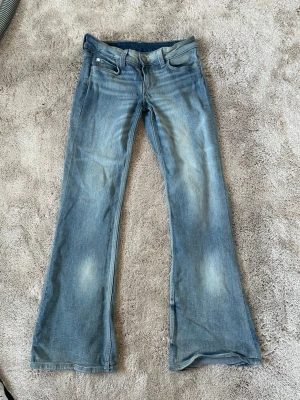 Blå bootcut jeans med slitningar - Säljer ett par ljusblå bootcut jeans. Storlek 28/30 passar mig som brukar ha xs-s