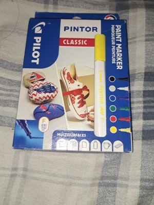 Pilot Pintor gul paint marker - Pilot Pintor Classic paint marker med gul färg och fin spets (0,9-1,5 mm). Perfekt för att rita eller dekorera på olika material som sten, tyg, plast och papper. Pennan är enkel att använda och ger ett täckande resultat.