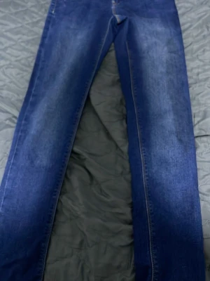 Blå raka jeans från Name It - Snygga blå jeans från Name It i rak modell. Klassisk denim med kontrastsömmar och knappstängning. Perfekta till en avslappnad stil och funkar året runt. Passar dig som gillar enkel och tidlös look.