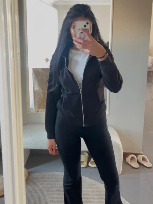 Svart kofta - Snygg svart hoodie med dragkedja framtill och huva. Klassisk passform och fickor på sidorna. Perfekt att slänga på sig över en t-shirt för en avslappnad look. Passar till det mesta och är enkel att matcha.