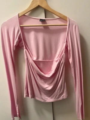 Ljusrosa långärmad topp med drapering - Trendig ljusrosa topp med lång ärm och snygg drapering framtill. 