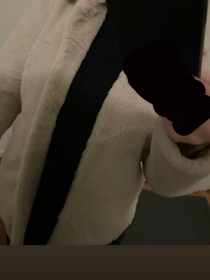 Beige päls kappa - Säljer en supermjuk beige pälskappa med klassisk krage och rak passform. Perfekt för dig som vill ha en trendig och varm look under kyliga dagar. Kappan kan matcha in med vilken stil du vill. 