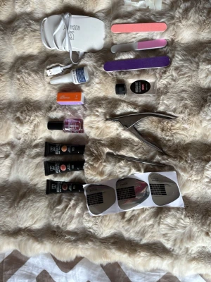 Nagelkit med UV-lampa och tillbehör - Komplett nagelkit med vit UV-lampa från Rosalind, flera nagelfilar i olika färger, nagelklippare, nagelmallar, nagelgel, buffer, nagelolja och USB-sladd. Perfekt för att fixa gelenaglar hemma. Innehåller även småflaskor med nagelprodukter och verktyg i metall.