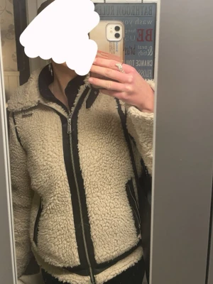Beige teddyjacka med svarta detaljer - Säljer en beige teddyjacka från bikbok med svarta detaljer. Älskar denna! Varm och mysig🥰
