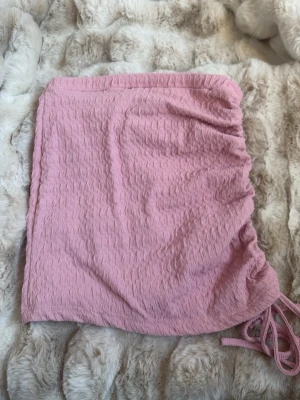 Rosa kortkjol med snörning - Säljer en rosa kortkjol med snygg snörningsdetalj på sidan. Kjolen är från SHEIN och storlek xxs! Använt bara nåra få gånger! 