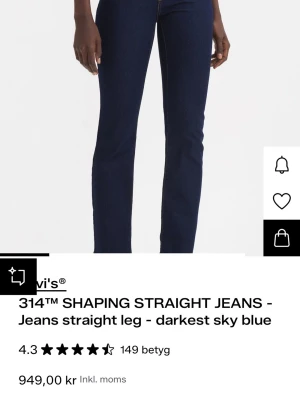 Levi's 314 Shaping Straight Jeans blå - Mörkblå shaping jeans från Levi's med rak passform och hög midja. Klassisk femficksmodell i stretchigt denimtyg som sitter snyggt och bekvämt. Perfekta till boots eller sneakers för en clean look. Använt MAX 5 gånger