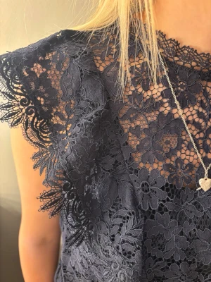 Mörkblå spetsblus med volanger - Snygg mörkblå blus i spets med blommigt mönster och volangdetaljer längs framsidan. Blusen är från Zara och använd ett fåtal gånger! Skitsnygg till sommaren💙💙storleken passar bra på mig som egentligen har S.  pris kan diskuteras 