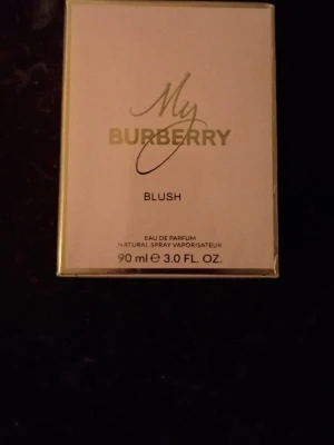 My Burberry Blush Eau de Parfum 90ml - Lyxig parfym från Burberry, My Burberry Blush, i en elegant ljusrosa och guldig förpackning. Eau de Parfum med fräsch och feminin doft, perfekt för dig som vill ha något exklusivt. Flaskan rymmer 90 ml och har en stilren design.