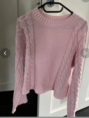Ljusrosa kabelstickad tröja Gina Tricot - Supersöt ljusrosa stickad tröja från Gina Tricot som ny utan prislapp, med kabelstickade detaljer längs ärmarna och sidorna. Tröjan har rund halsringning och ribbade muddar. Perfekt för dig som vill ha en mysig och trendig look.