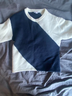 Trendig stickad tröja från Gina tricot💗 - Säljer en snygg stickad tröja från Gina Tricot i storlek 170. Tröjan har ett coolt blockmönster i marinblått och vitt, rund halsringning och raka ärmar. Perfekt för dig som gillar en stilren men ändå trendig look. Materialet känns mjukt och bekvämt.