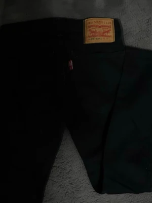 Svarta Levi's 519 Hi-Ball jeans - Säljer ett par svarta Levi's 519 Hi-Ball jeans med klassisk läderpatch bak och röd Levi's-tagg vid fickan. Jeansen har smal passform och är tillverkade i slitstarkt denimtyg. Perfekta för en clean och stilren look.