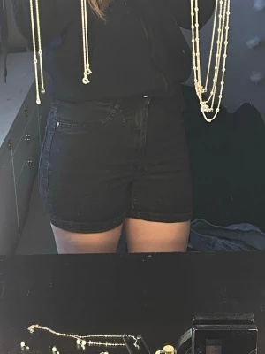 Svarta högmidjade shorts - Säljer ett par svarta högmidjade shorts i klassisk femficksmodell. De har en slim passform och är perfekta till sommaren. Stilen är enkel och tidlös, vilket gör dem lätta att matcha med olika toppar. Sitter som S/M, ej bra pris skriv till mig