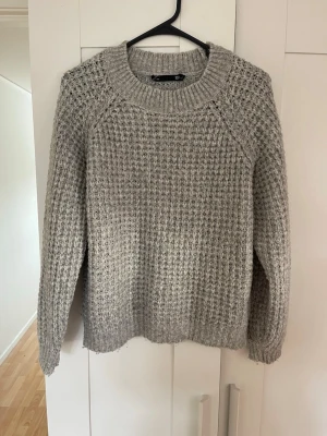 Grå stickad tröja från lager 157 stl L - Säljer en grå stickad tröja från lager 157 med grov struktur och rund hals. Tröjan har långa ärmar och ribbade muddar vid ärmslut och nederkant. Perfekt för kalla dagar och enkel att matcha med olika outfits. Tveka inte på att höra av dig om du har några frågor!💕 svarar snabbt