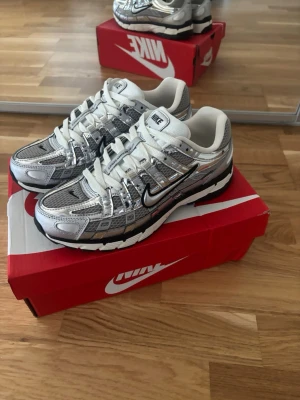 Nike P-6000 metallic silver - Nike p-6000 metallic silver i ett nytt skick. Skorna är väldigt fina men även ganska svåra att få tag på eftersom att det är stor efterfrågan. Jag säljer pågrund av att jag fick hem dem och så var dem lite stora för mig men dem är normala i storlek.