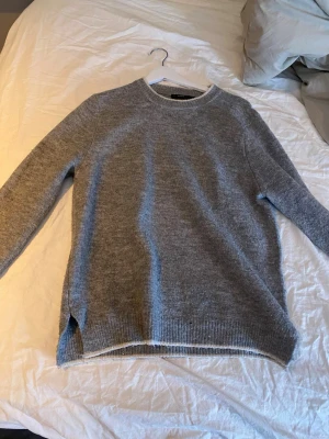 grå stickad tröja i storlek M - jätte fin stickad tröja i storlek M, den är lite knopprig men inget man tänker på