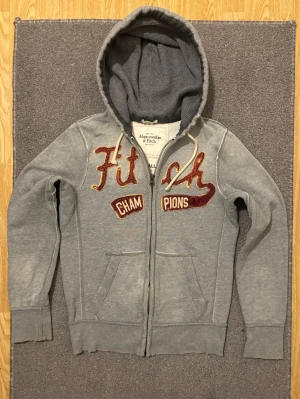 Vintage Abercrombie & Fitch Zip Hoodie - Säljer denna tvär feta och unika Abercrombie & Fitch zip hoodien!  | Storlek S | Mycket bra skick, förutom små fläckar som knappast syns, se sista bild| Längd ≈ 66cm, Bredd armhåla - armhåla ≈ 53 cm | Modell 175cm, 68kg | Hör av vid fler frågor, priset kan diskuteras!